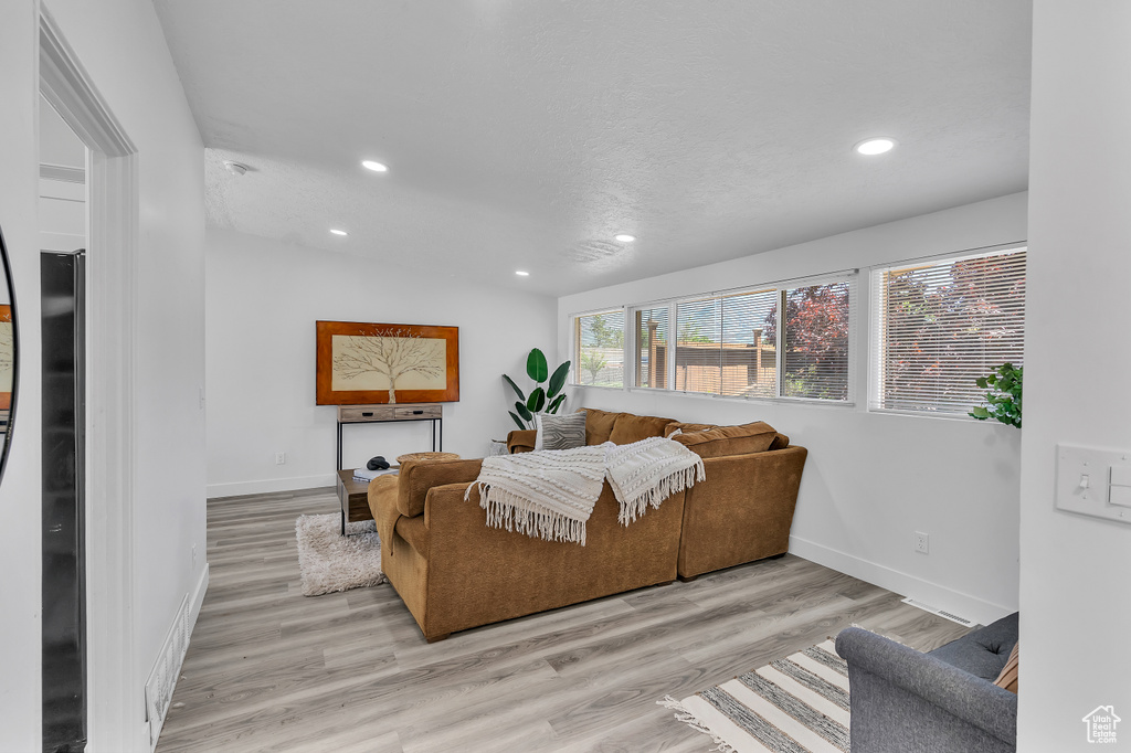 Living room with light hardwood / wood-style floors and vaulted ceiling