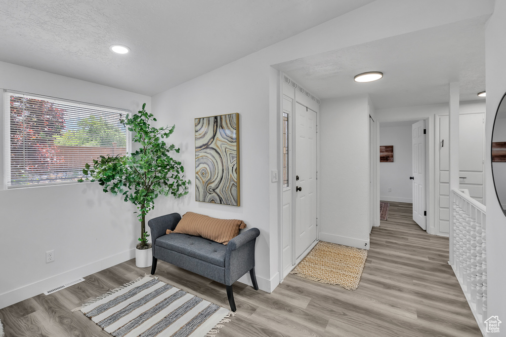 Sitting room with light hardwood / wood-style flooring and lofted ceiling