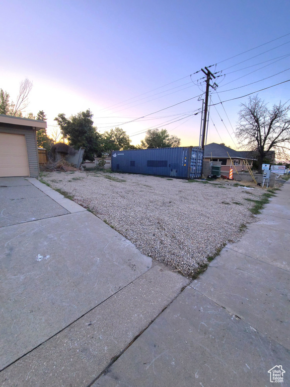 Yard at dusk featuring a garage