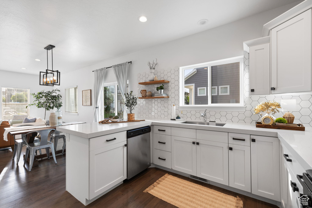 Kitchen featuring stainless steel dishwasher, dark hardwood / wood-style floors, backsplash, a healthy amount of sunlight, and sink