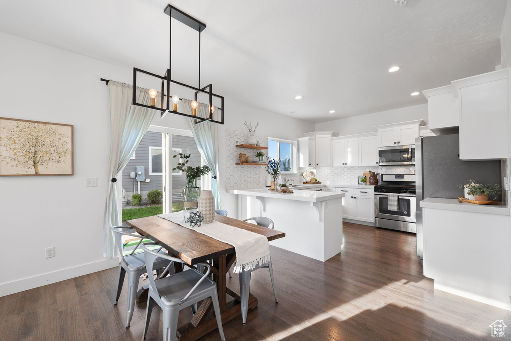 Dining room featuring a healthy amount of sunlight, a chandelier, and dark hardwood / wood-style floors