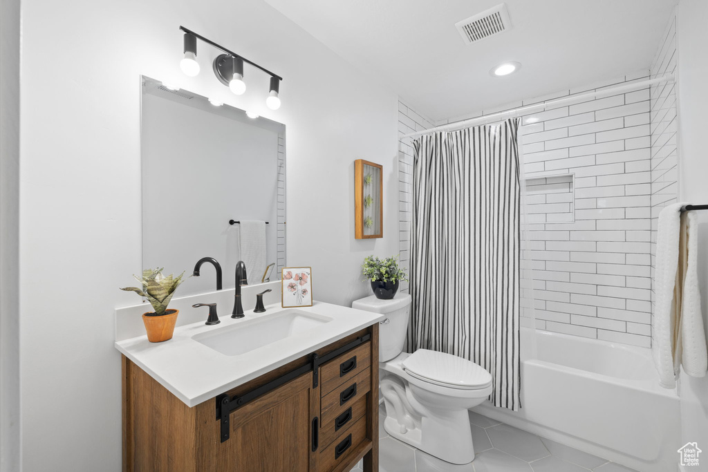 Full bathroom featuring tile flooring, vanity, toilet, and shower / tub combo