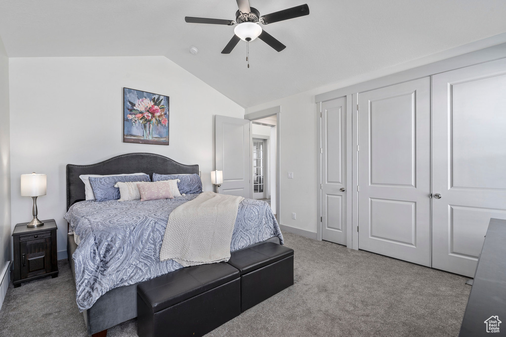 Carpeted bedroom with ceiling fan and lofted ceiling