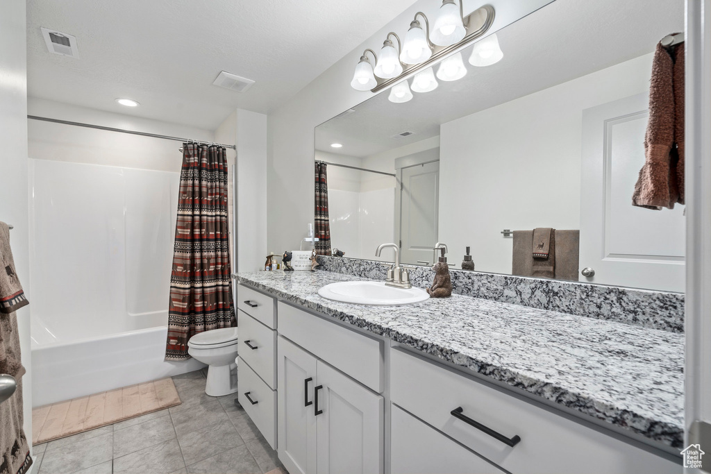 Full bathroom featuring shower / bathtub combination with curtain, tile flooring, toilet, and large vanity