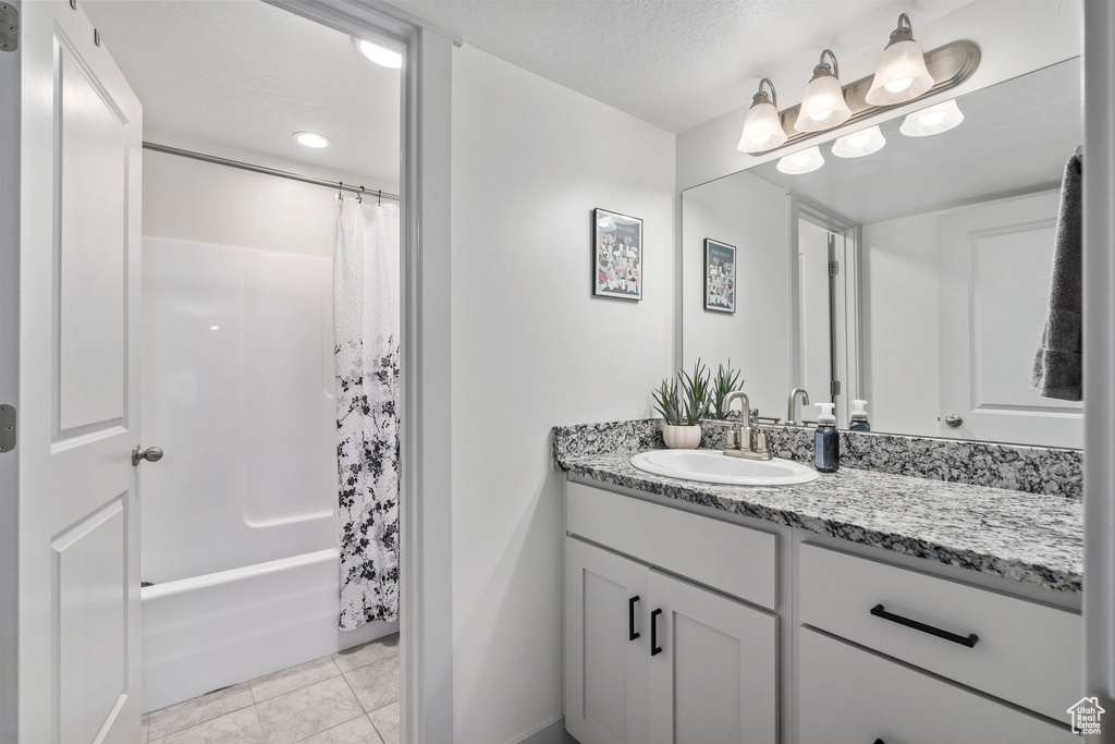 Bathroom with tile flooring, vanity, and shower / bath combo with shower curtain