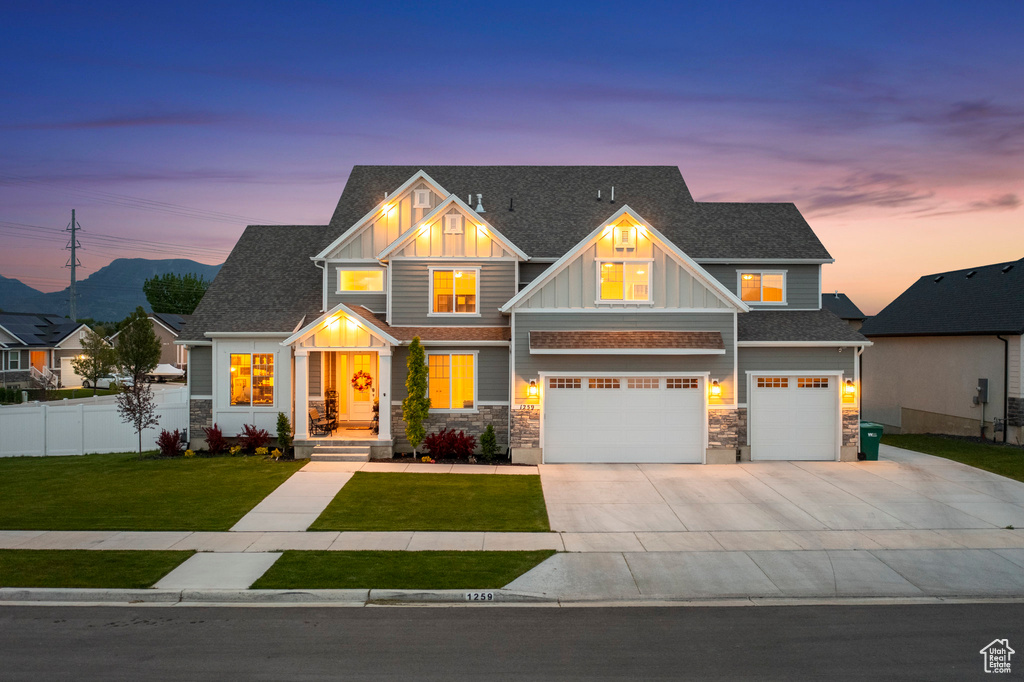 Craftsman-style house featuring a garage and a yard