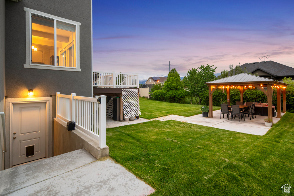 Yard at dusk with a patio and a gazebo