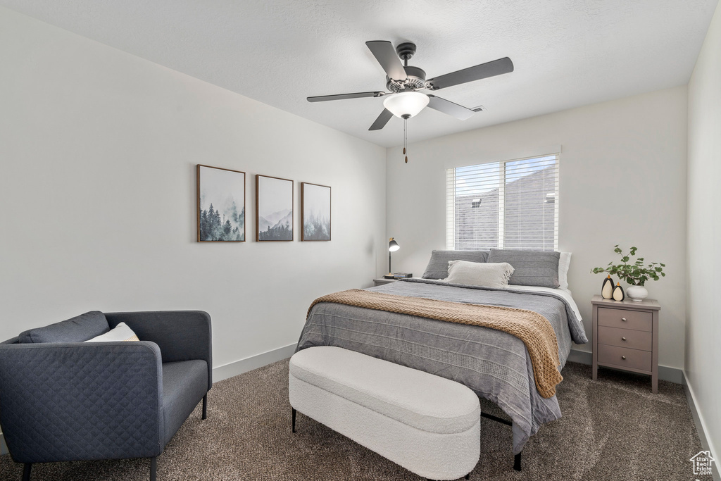 Carpeted bedroom featuring ceiling fan