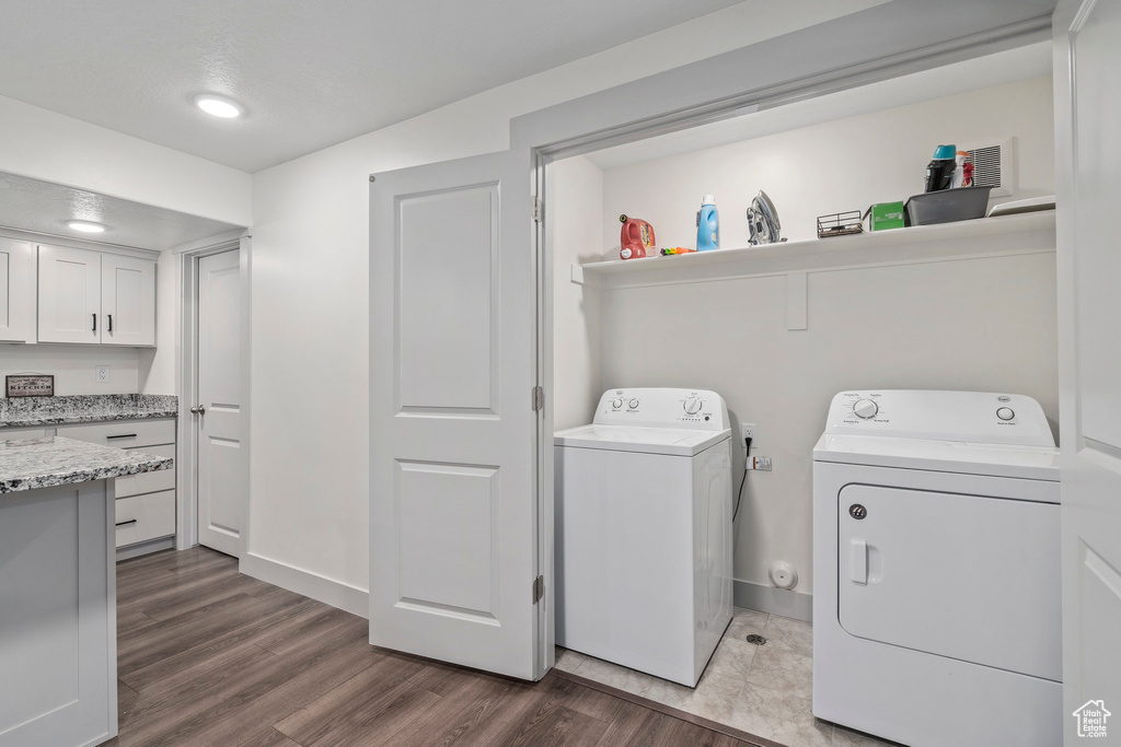 Washroom with independent washer and dryer and dark hardwood / wood-style flooring