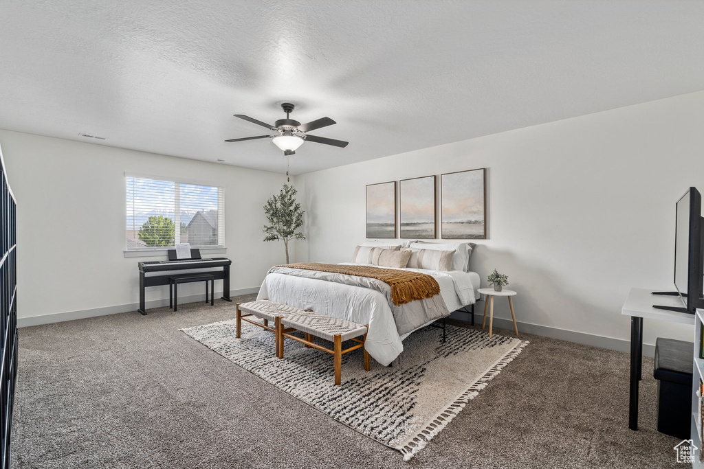 Carpeted bedroom featuring ceiling fan