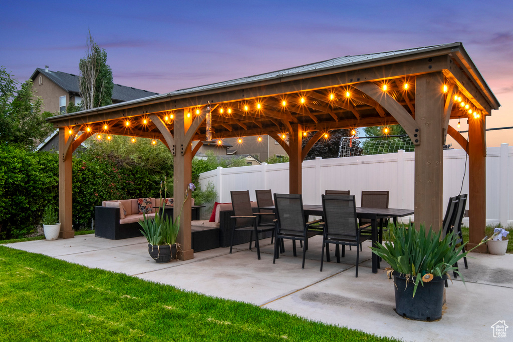 Patio terrace at dusk featuring an outdoor hangout area and a gazebo