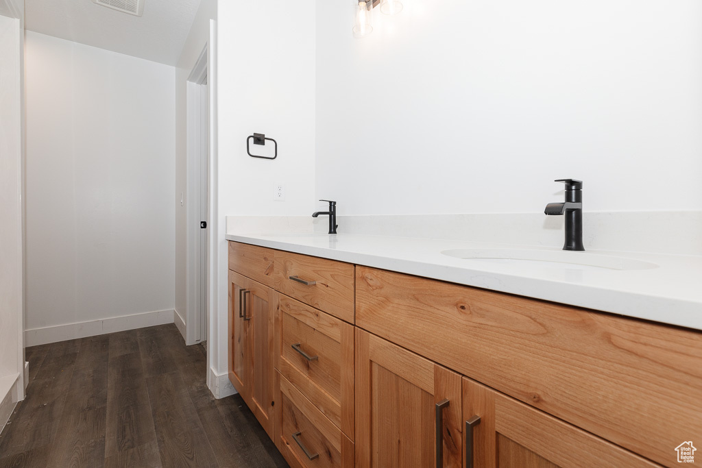 Bathroom with dual vanity and hardwood / wood-style floors