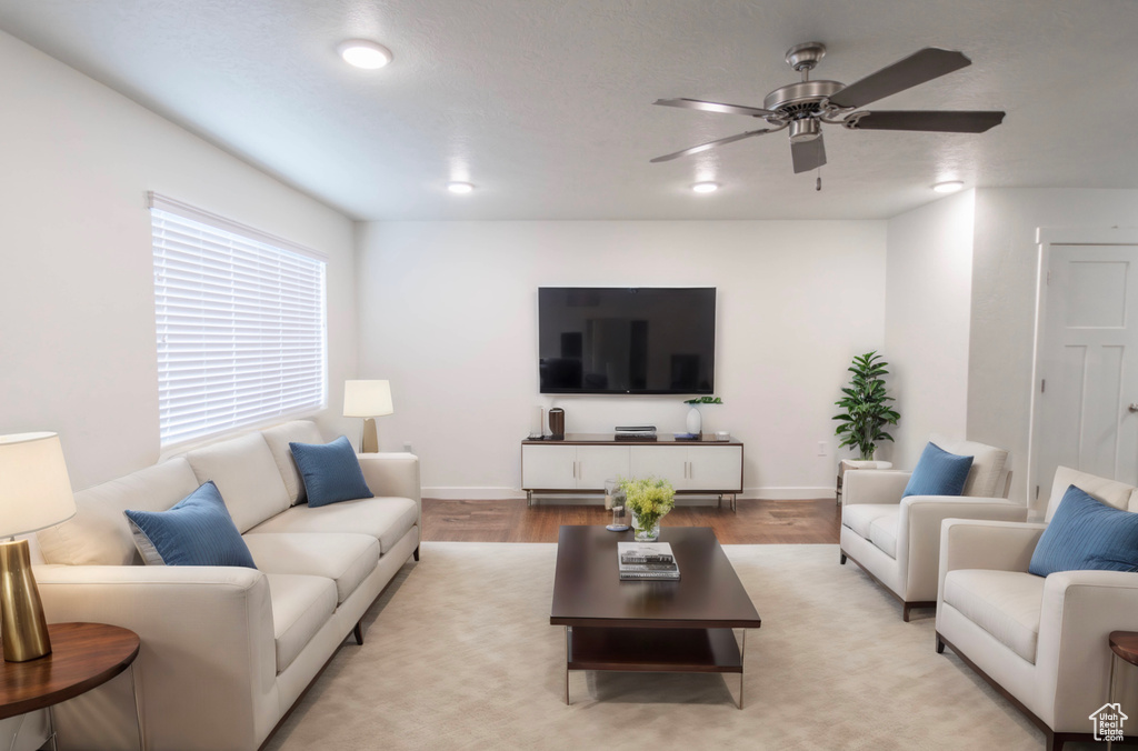 Living room with ceiling fan and light hardwood / wood-style flooring