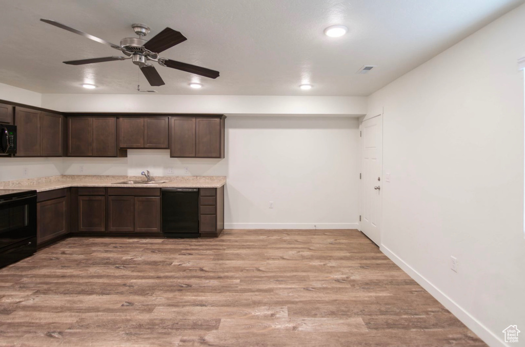 Kitchen with light hardwood / wood-style flooring, black appliances, dark brown cabinetry, sink, and ceiling fan