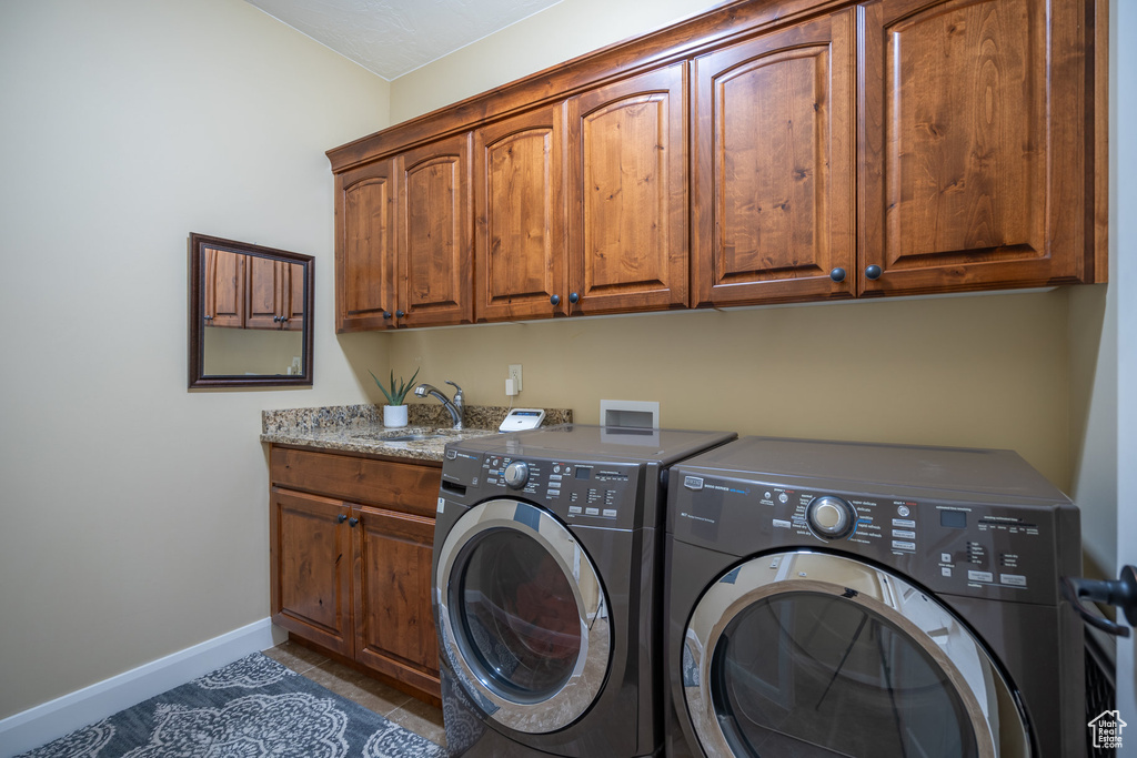 Laundry room featuring cabinets, washing machine and clothes dryer, hookup for a washing machine, sink, and light tile floors