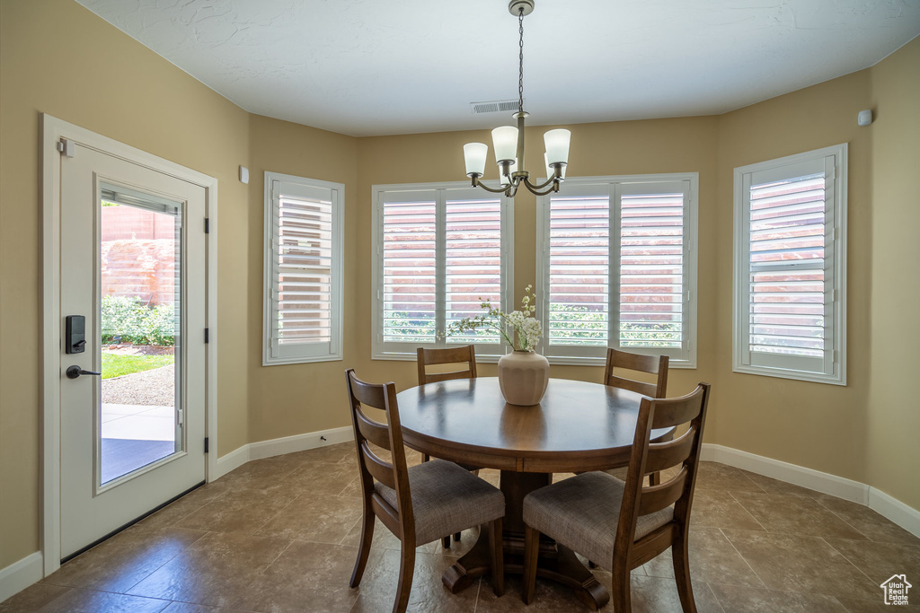 Dining space with a notable chandelier and tile flooring