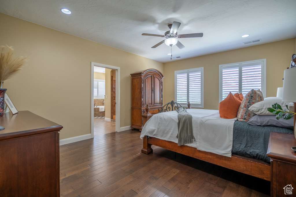 Bedroom with ceiling fan, ensuite bath, and dark wood-type flooring