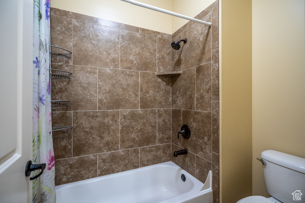 Bathroom with toilet and shower / bath combo with shower curtain