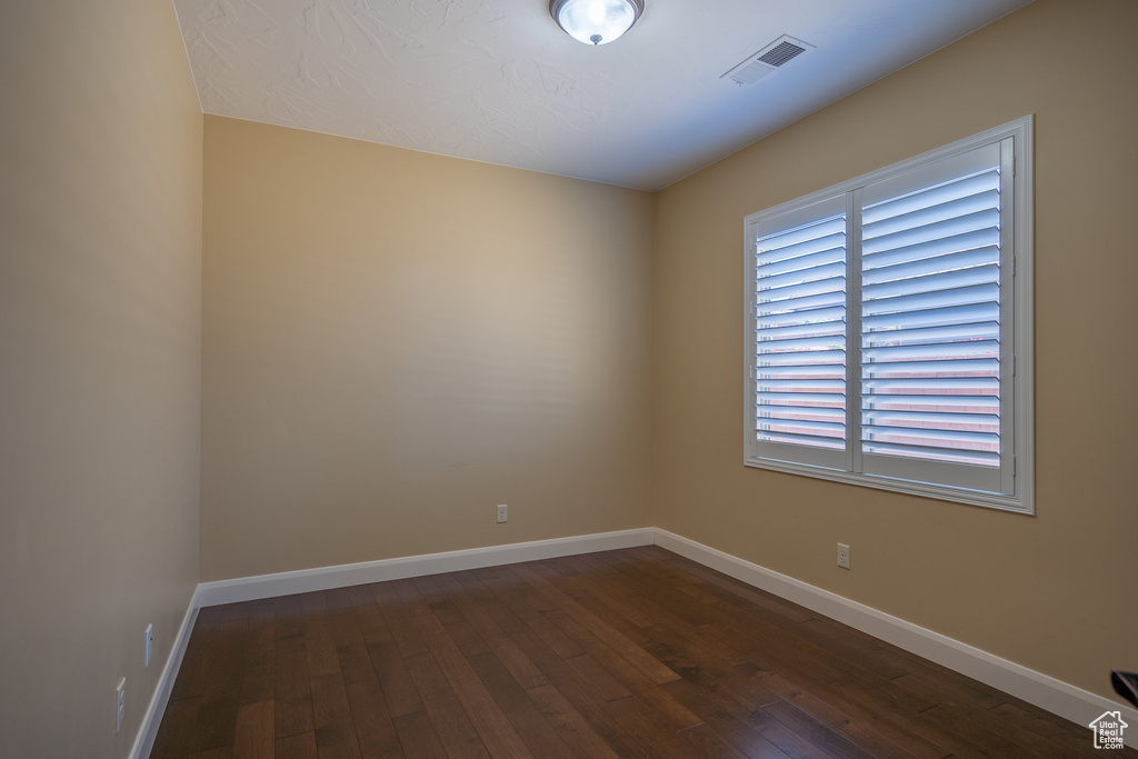 Empty room with hardwood / wood-style flooring