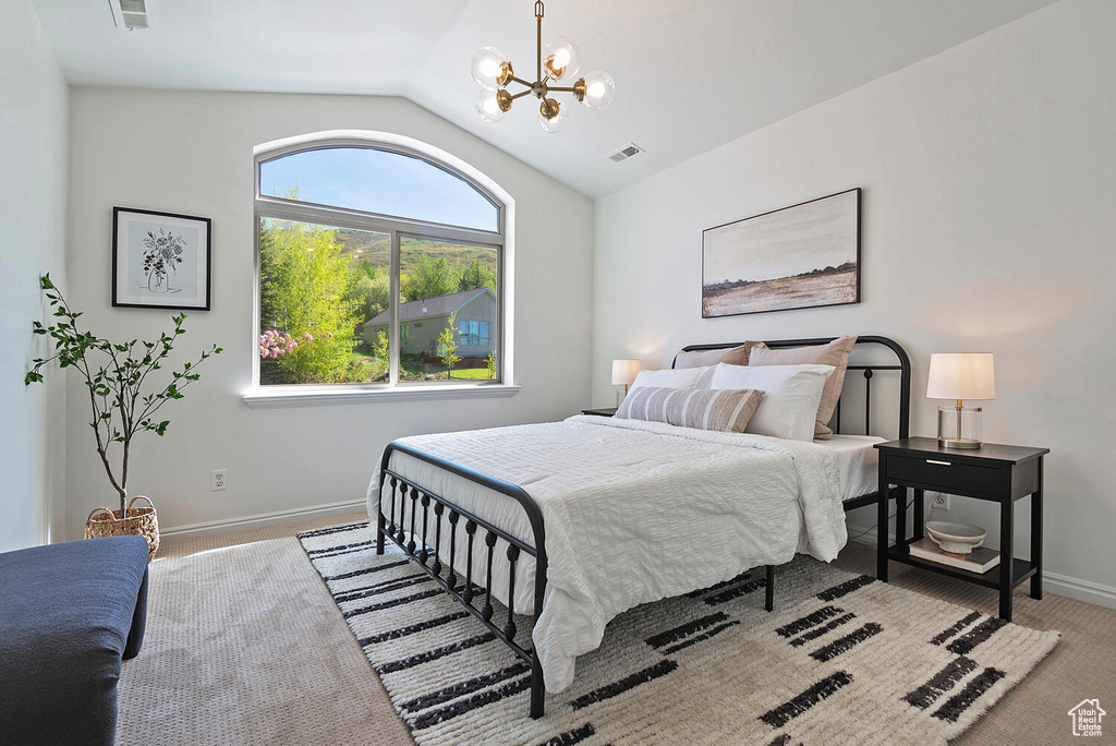 Bedroom featuring a notable chandelier and lofted ceiling