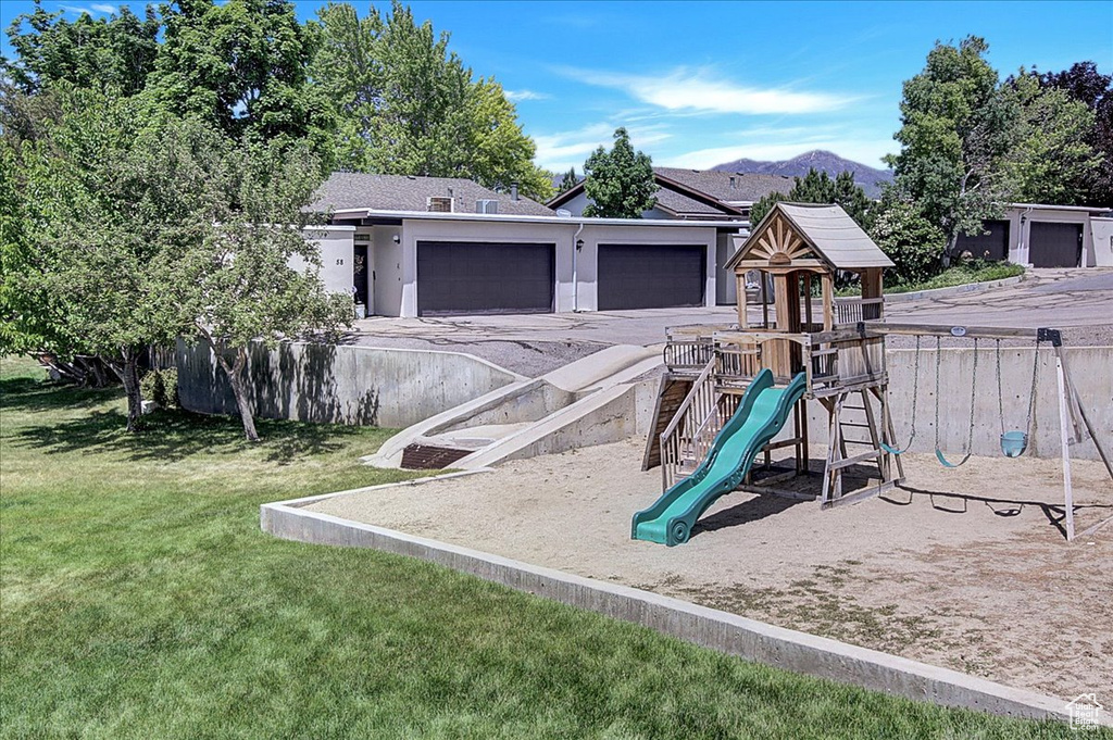 View of play area with a mountain view and a lawn