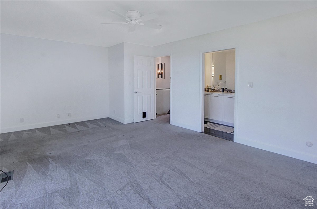 Unfurnished room featuring dark colored carpet and ceiling fan