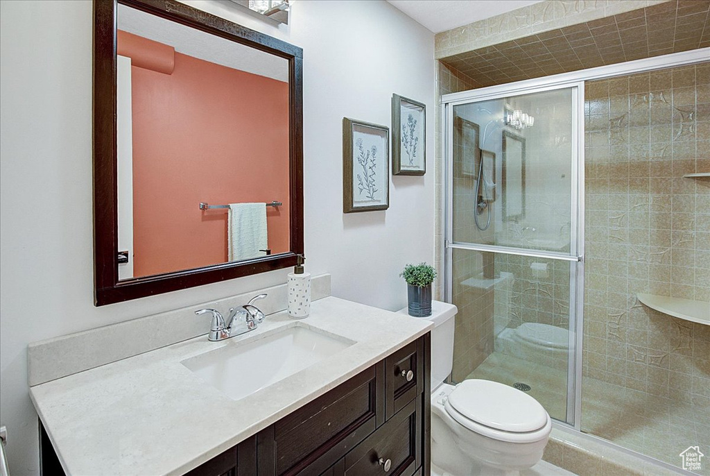 Bathroom with an enclosed shower, toilet, and vanity