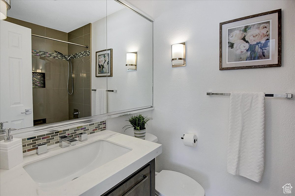 Bathroom with tasteful backsplash, toilet, and vanity