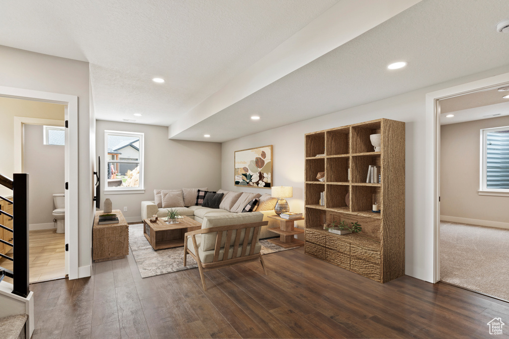 Living room with a wealth of natural light and dark hardwood / wood-style flooring