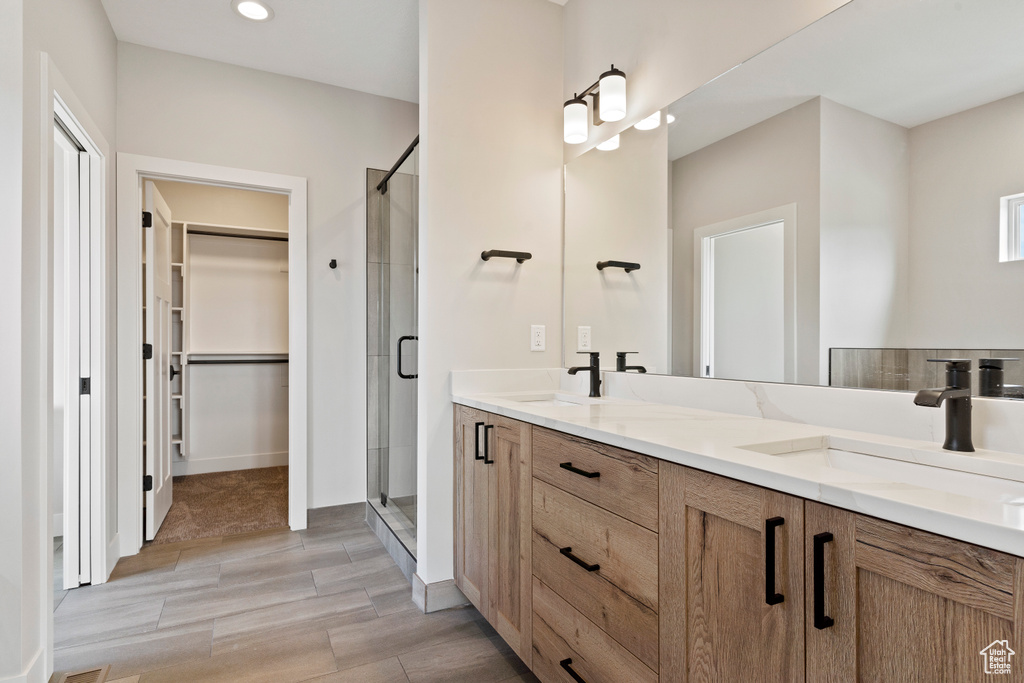 Bathroom featuring vanity, a shower with shower door, and hardwood / wood-style flooring