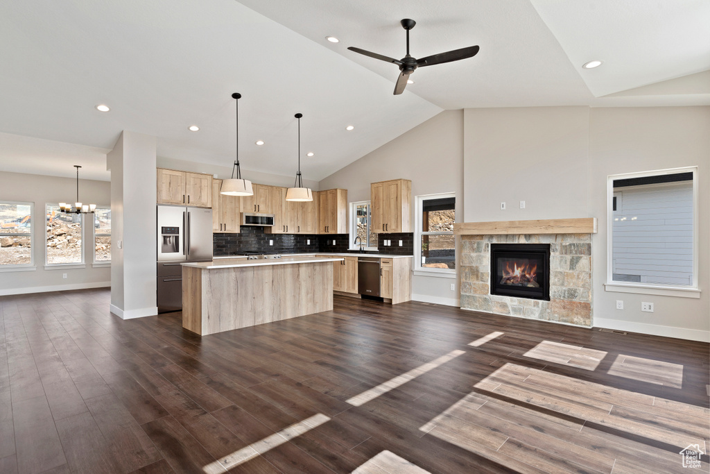 Kitchen featuring hanging light fixtures, ceiling fan with notable chandelier, a kitchen island, and dark hardwood / wood-style floors