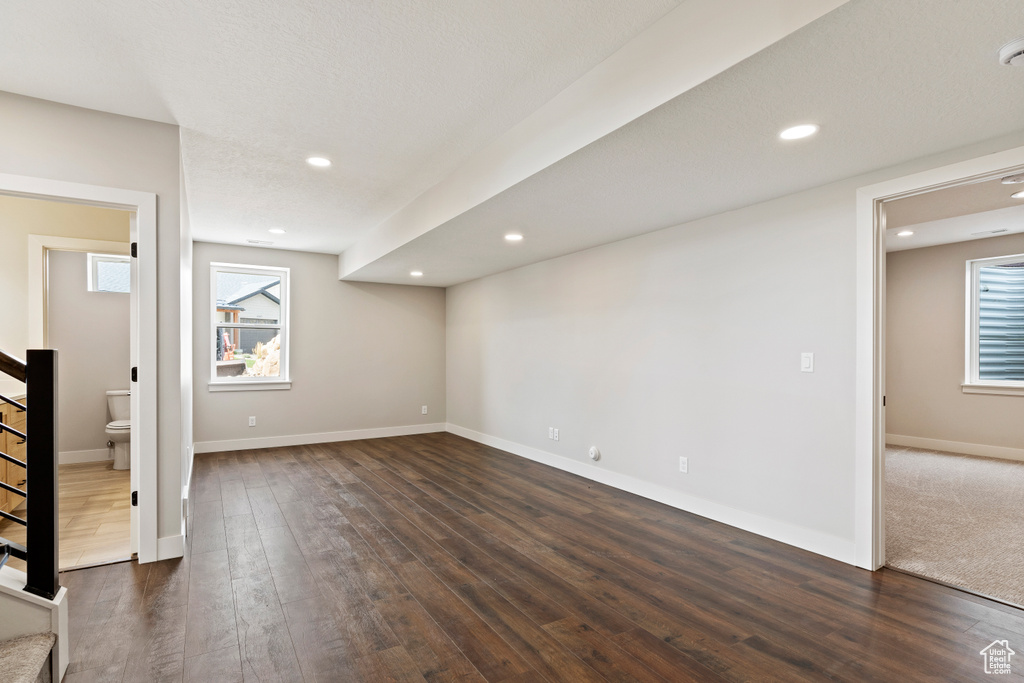 Unfurnished room featuring dark hardwood / wood-style flooring and a wealth of natural light