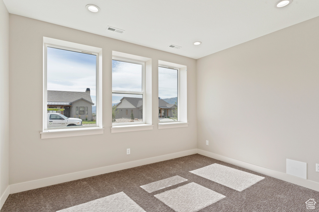 Spare room featuring dark colored carpet