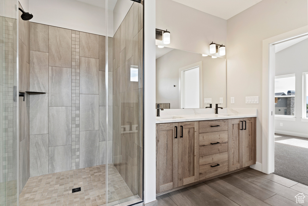 Bathroom with an enclosed shower, hardwood / wood-style flooring, and vanity