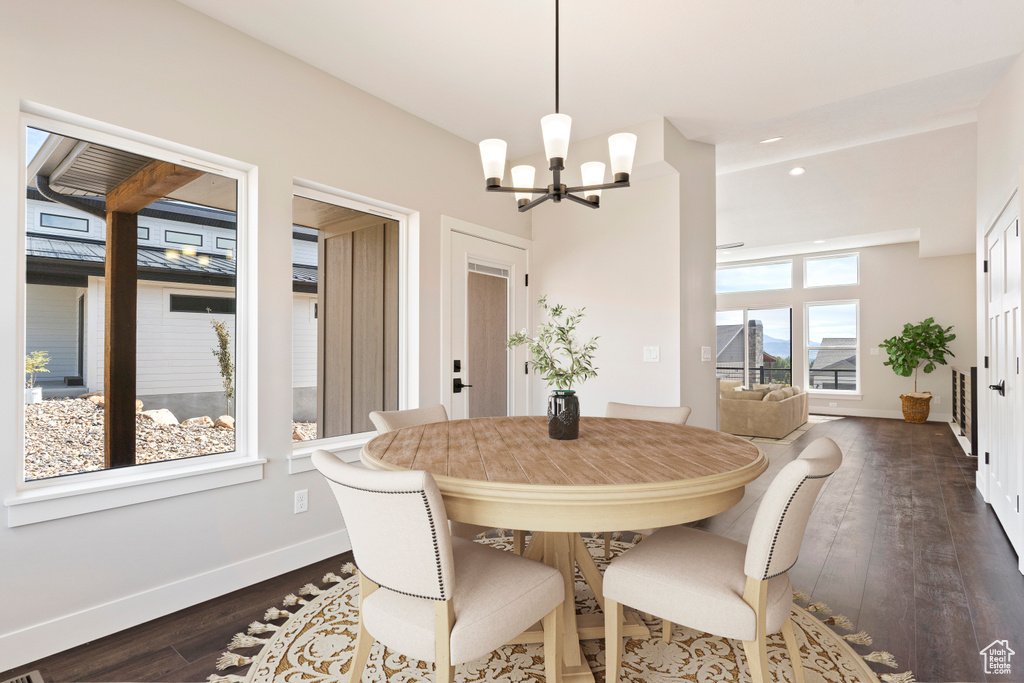 Dining space featuring an inviting chandelier and dark hardwood / wood-style floors