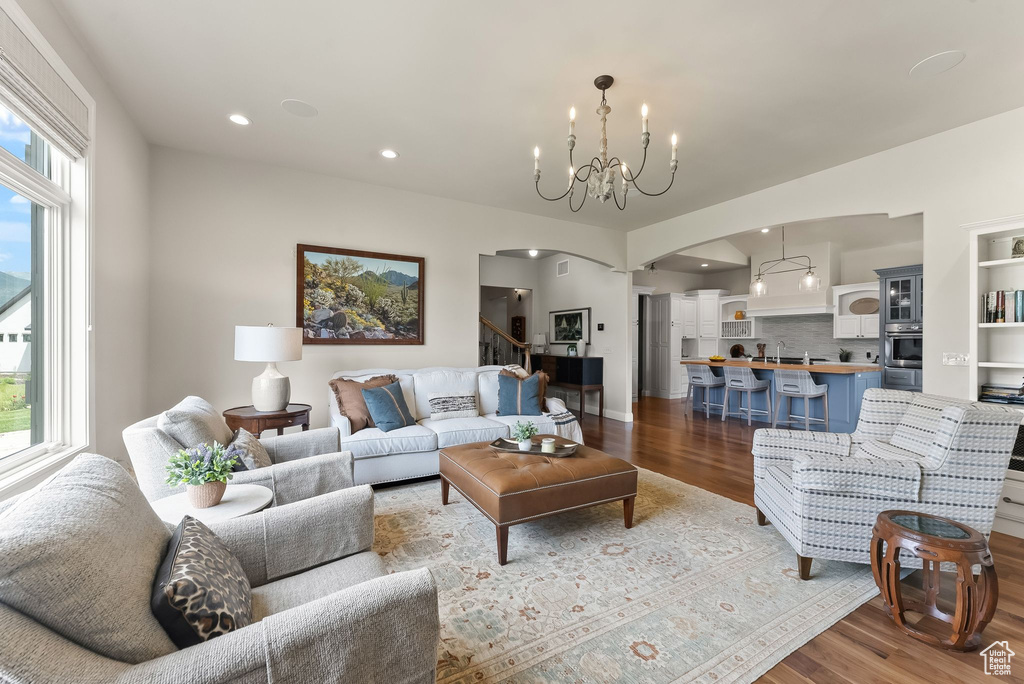 Living room with sink, hardwood / wood-style flooring, and a chandelier