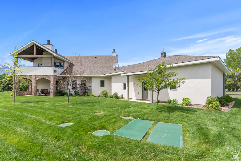 Back of house with a lawn