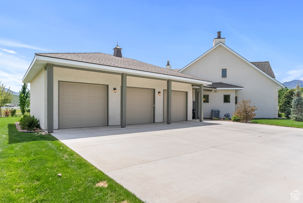 View of front of property featuring a front yard and a garage