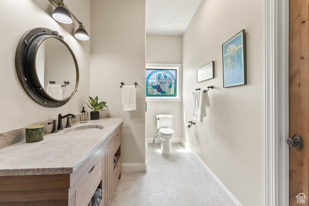 Bathroom with tile flooring, toilet, and large vanity