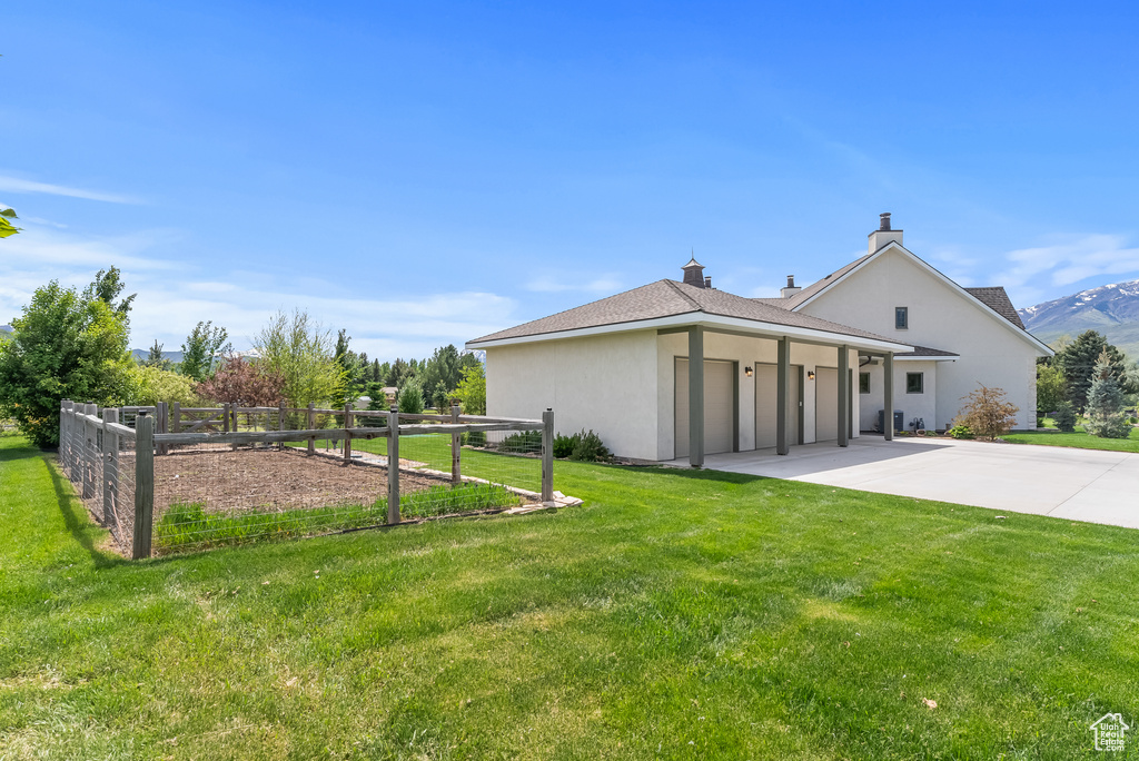 Rear view of house with a garage and a yard