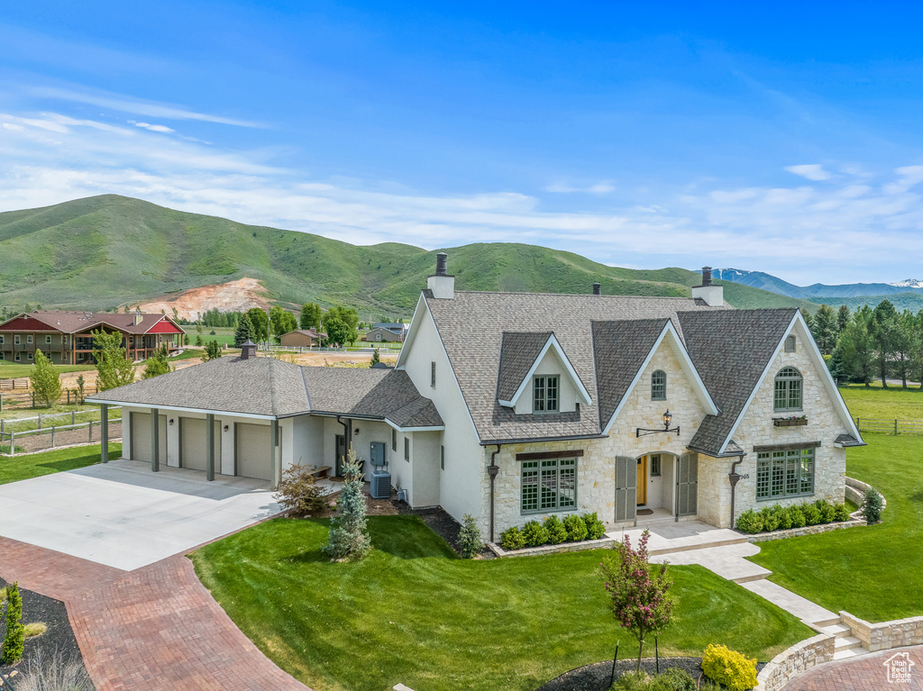 View of front of home featuring a garage, a front yard, and a mountain view