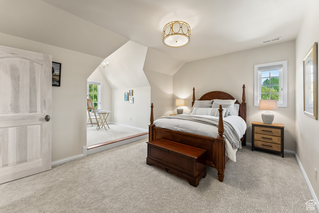 Carpeted bedroom featuring lofted ceiling