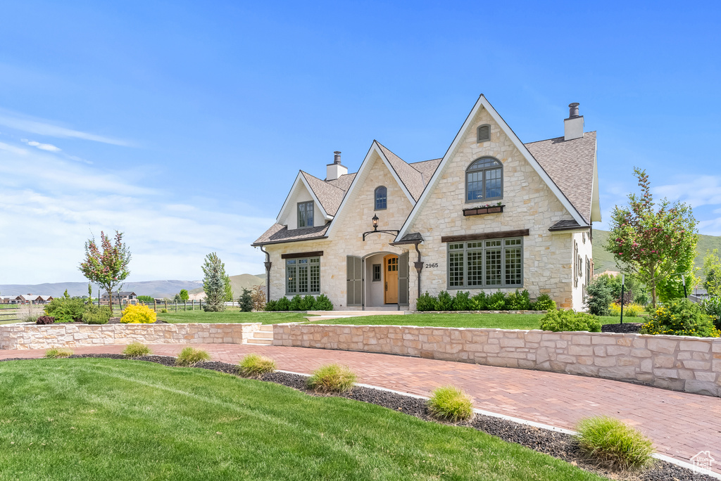 French country inspired facade with a front yard