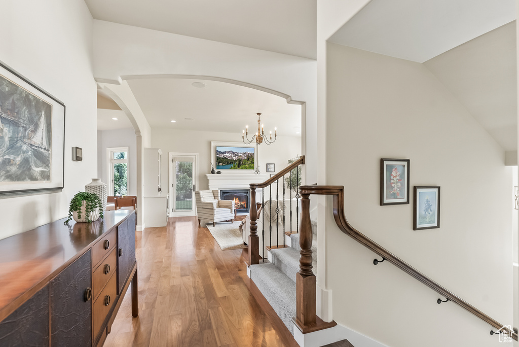 Entrance foyer featuring a notable chandelier, vaulted ceiling, and hardwood / wood-style flooring