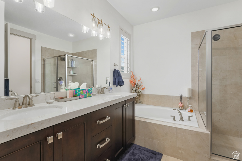 Bathroom with tile floors, dual sinks, oversized vanity, and independent shower and bath