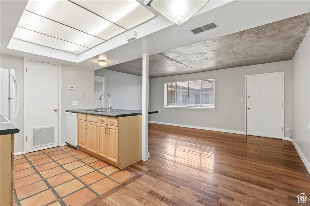 Kitchen featuring white appliances, sink, light wood-type flooring, and light brown cabinets