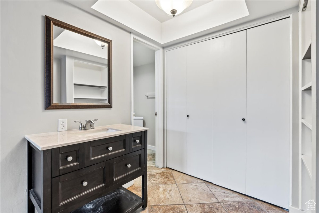 Bathroom with built in features, vanity, and tile floors