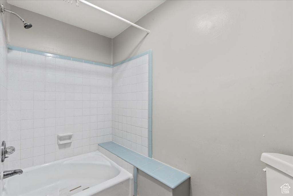 Bathroom featuring toilet and tiled shower / bath combo