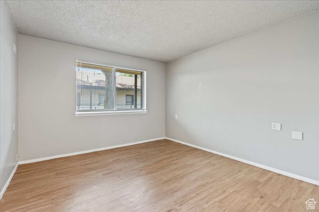 Spare room with light hardwood / wood-style floors and a textured ceiling