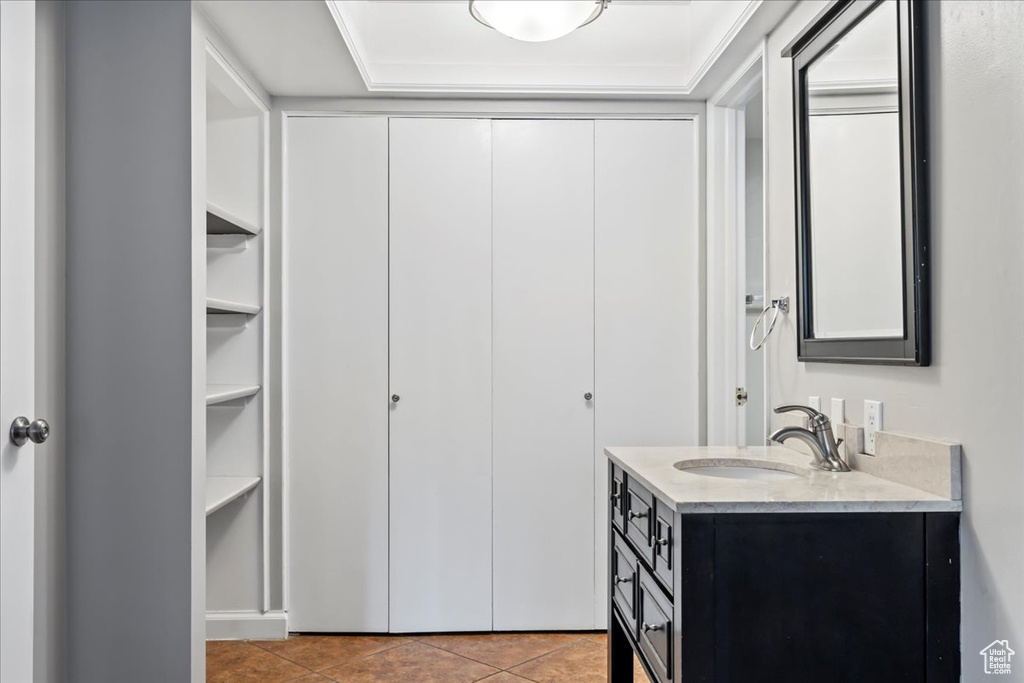 Bathroom with vanity with extensive cabinet space and tile floors